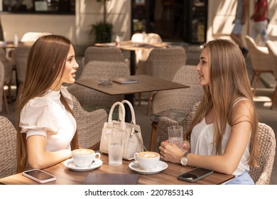 Two Girlfriends Talking In A Outside Cafe Bar