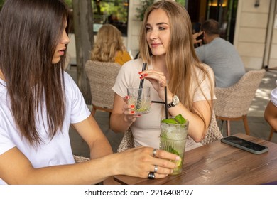 Two Girlfriends Talking In A Outside Cafe Bar