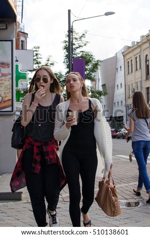Two girlfriends are walking on ththe city streets