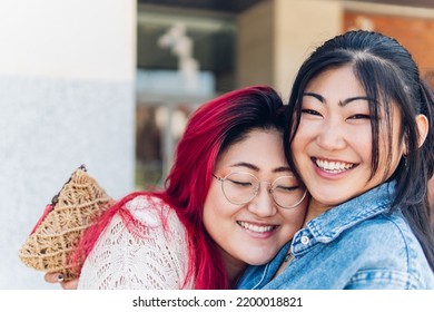 Two Girls, Asian Friends Hugging And Smiling And Happy With White Teeth And A Perfect Smile.