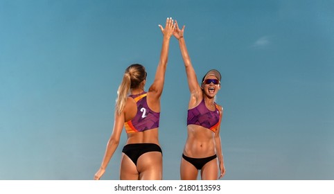 Two girls athlets volleyball players on the beach celebrating victory - Powered by Shutterstock