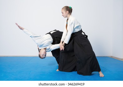 Two girls in black hakama practice Aikido on martial arts training