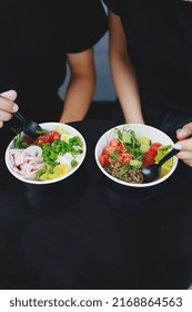 Two Girls In Black T-shirts Eating Healthy Bowls With Vegetables