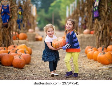 Two Girls Carrying a Pumpkin