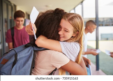 Two Girls Celebrating Exam Results In School Corridor