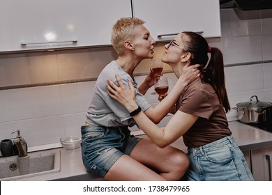 Two girls chatting with each other in the kitchen, love relationship same-sex couple girls. Family and family relationships.