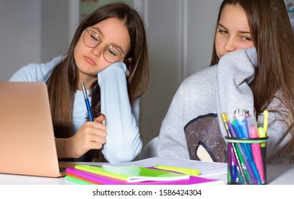 Two Girls Do Homework With The Help Of The Laptop. Too Much Information Can Bring Fatigue And Exhaustion. The Concept Of Communication And Navigation, The Internet, Social Network.