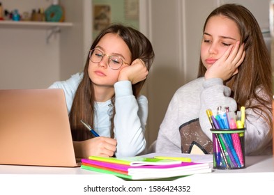 Two Girls Do Homework With The Help Of The Laptop. Too Much Information Can Bring Fatigue And Exhaustion. The Concept Of Communication And Navigation, The Internet, Social Network.