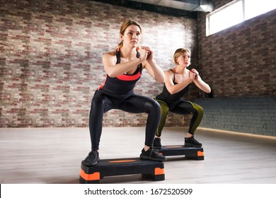 Two girls doing step aerobics in the gym - Powered by Shutterstock