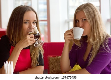 Two Girls Drinking Coffee In A Cafeteria