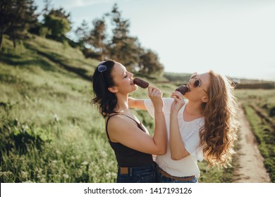 two girls eat ice cream, summer fun, at sunset, outdoor