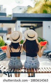 Two Girls Eating Watermelon By The Pool In Thailand