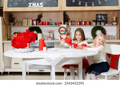 Two girls enjoying a Christmas-themed tea party in a festive kitchen. Two young girls having tea in a festive Christmas kitchen decorated with red poinsettias, candles, and holiday wreaths. - Powered by Shutterstock