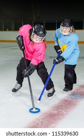 Two Girls fight for the ring, Ringette is a Canadian Ice sport played in a hockey rink or arena.