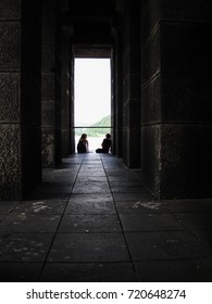 Two Girls, Friends In The Middle Of Deep Conversation In The End Of Long Deep Hall Inside Horse Statue In Koblenz, Germany                               