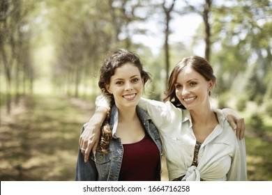 Two Girls, Friends Smiling With Their Arms Around Each Other.