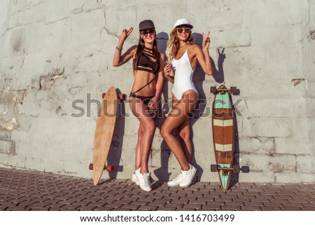 Similar – Image, Stock Photo Two women holding surfboard and looking at camera