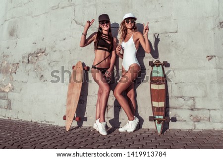 Similar – Image, Stock Photo Two women holding surfboard and looking at camera