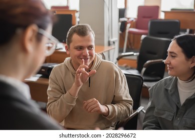 Two Girls And A Guy Are Talking In Sign Language. Three Deaf Students Chatting In A University Classroom.