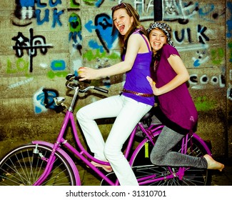 two girls having fun on a bicycle, personal editing ,green toning - Powered by Shutterstock