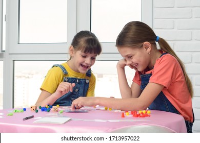 Two Girls Having Fun Playing A Board Game