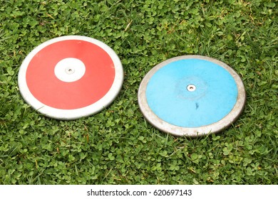 Two girls high school 1K discus on a green grass field - Powered by Shutterstock