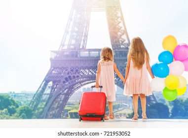 Two girls holding hands while walking around Paris