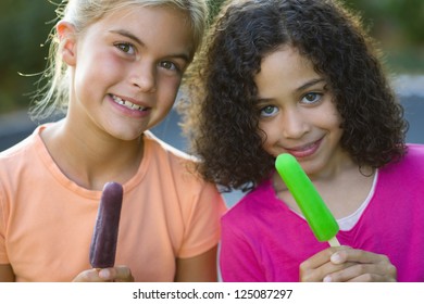 Two Girls Holding Popsicles