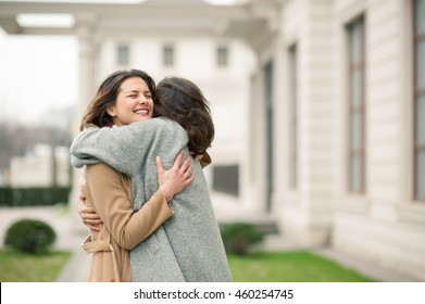 Two Girls Hug On The Sidewalk. Feel Joyfull And Happy Togather.