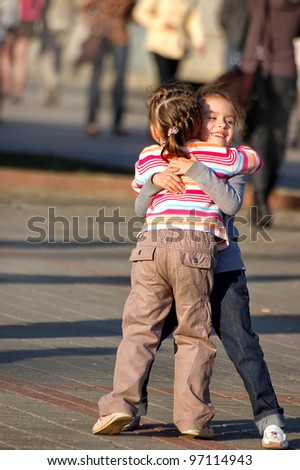 Similar – Two children laughing while playing in the playground.