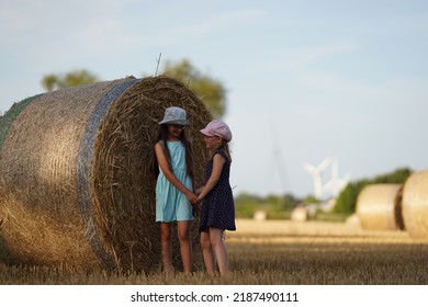 Two Girls Joking Around A Haystack