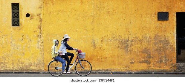 Two Girls On Bicycle With Old Wall In Vietnam