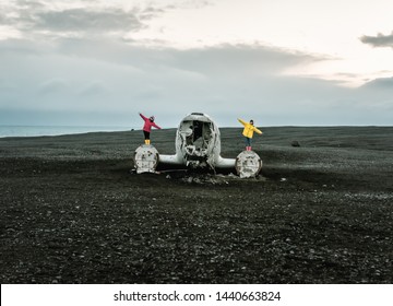 two girls on remains (wreck) of the broken plane in Iceland