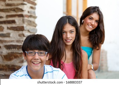 Two Girls And One Boy Looks At The Camera And Focus On The Girl In The Background