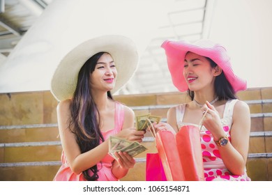 Two Girls In A Pink Dress And A Pink Hat Leave Shopping At A Shopping Mall With A Product Coming Together. During Summer Holidays