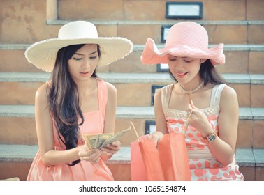 Two Girls In A Pink Dress And A Pink Hat Leave Shopping At A Shopping Mall With A Product Coming Together. During Summer Holidays