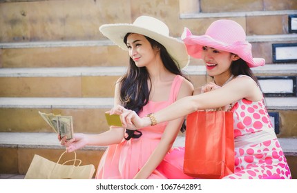 Two Girls In A Pink Dress And A Pink Hat Leave Shopping At A Shopping Mall With A Product Coming Together. During Summer Holidays