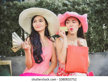 Two Girls In A Pink Dress And A Pink Hat Leave Shopping At A Shopping Mall With A Product Coming Together. During Summer Holidays