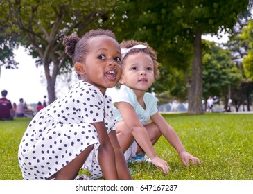 Two Girls Play Leap Frog In The Park