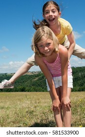 Two Girls Playing Leapfrog In Field