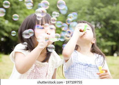 Two Girls Playing With Soap Bubbles