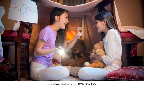 Two Girls Playing In Tepee Tent In Bedroom And Telling Stories