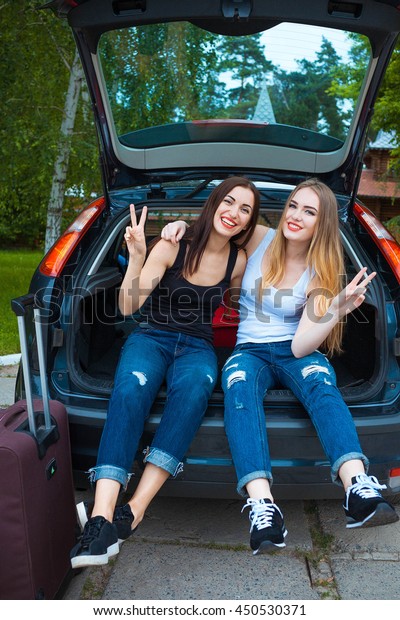 Two girls posing in car. Resting in the\
country. taking a trip somewhere by\
car