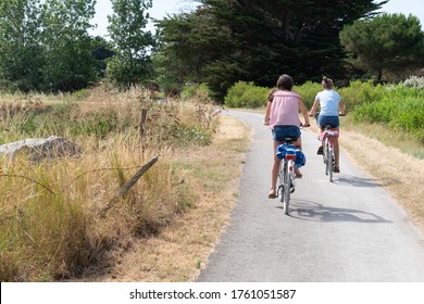 Two Girls Ride Bike In Path Bikeway In Ile De Noirmoutier Island In France Vendée