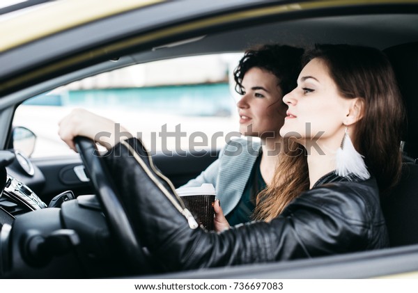 Two girls are riding in a\
car