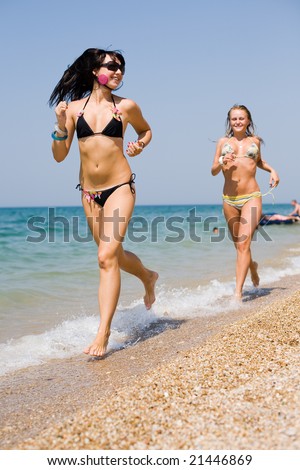 Two girls running on seashore