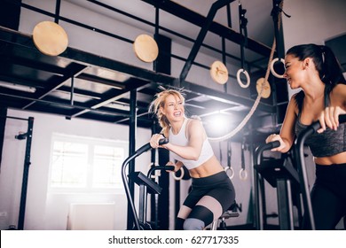 Two girls training on the exercise machine in the gym. - Powered by Shutterstock