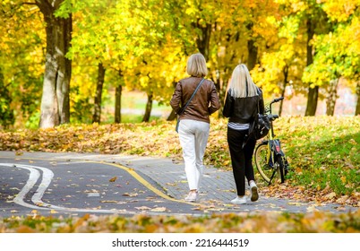 Two Girls Walking In The Autumn Park