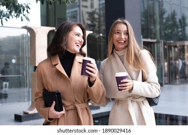 Two girls walking on the street. laughing and enjoy the life shopping and drink coffee. happy wide smile of women. friends meeting and talking.