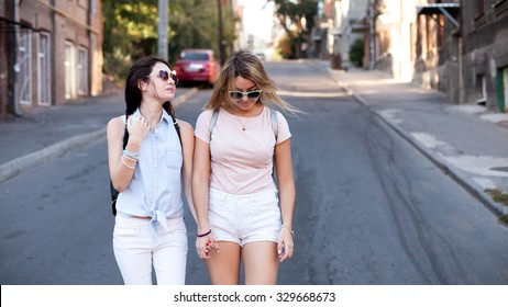 Two Girls Walking On The Street. Street Portrait